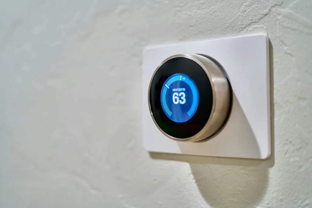 A smart thermostat mounted on an interior home wall