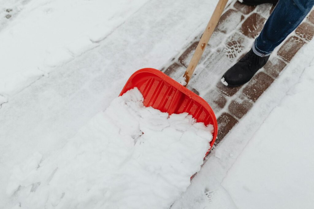 A homeowner shovels snow from a walkway