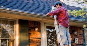 A homeowner inspects his gutters after a Minnesota winter
